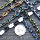 Colorful beaded bracelets on a wooden surface with a US quarter coin for size comparison.